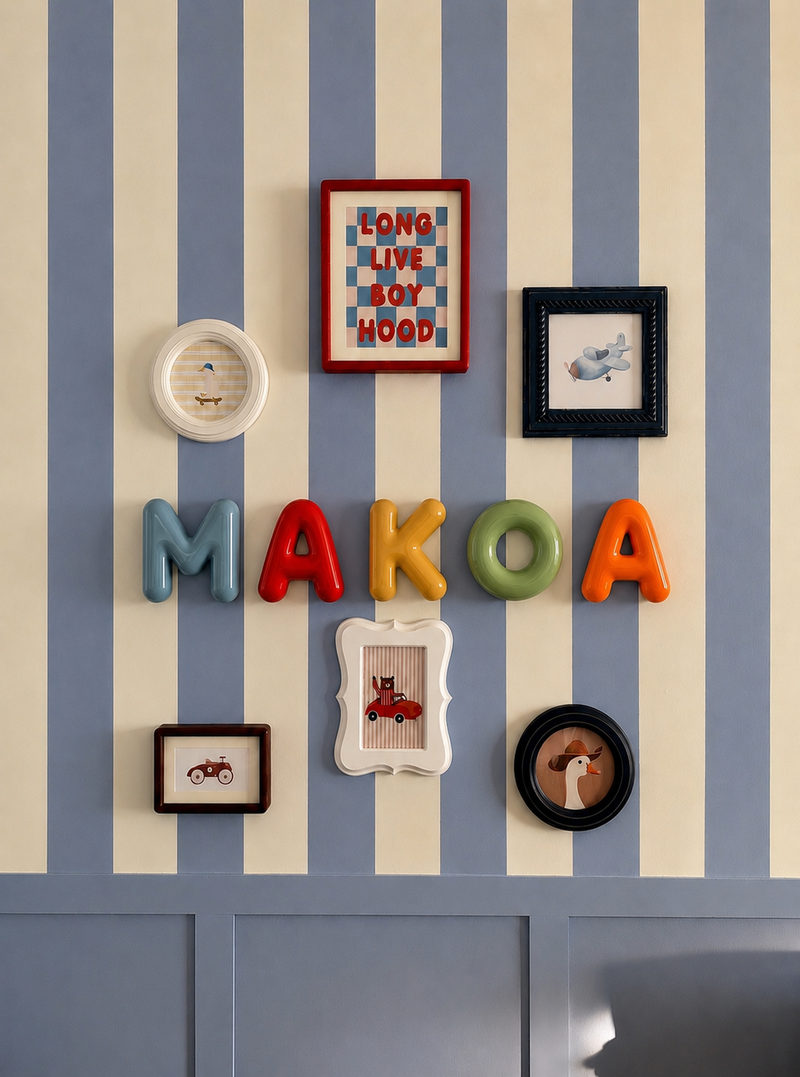 Door name sign spelling MAKOA on a striped wall