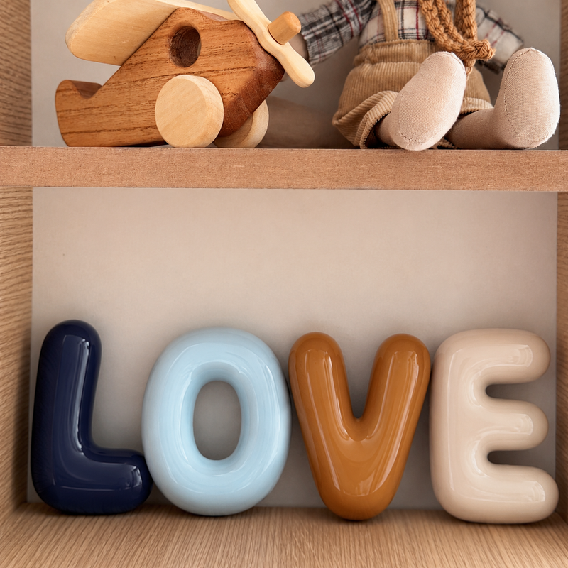 Bubble letters spelling LOVE displayed on a wooden shelf